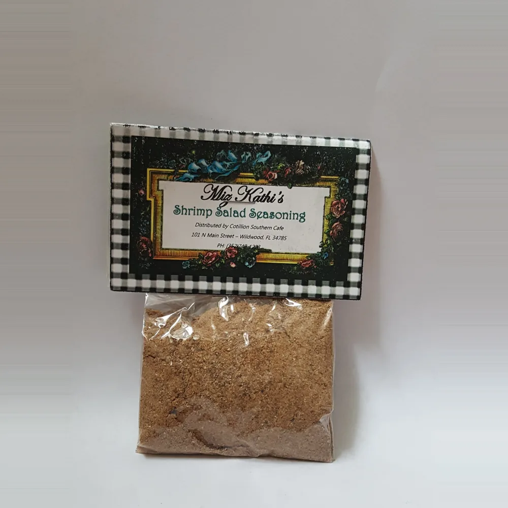 A clear bag of Miz Kathi’s Shrimp Salad Seasoning under a black-and-white gingham label